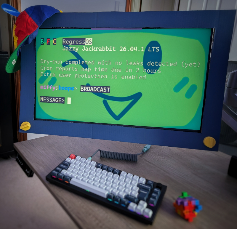 A blue cardboard square is placed around a monitor. The monitor screen background is the face of VBFC Boop. The message of the day shows a fictional BFC RegressOS.